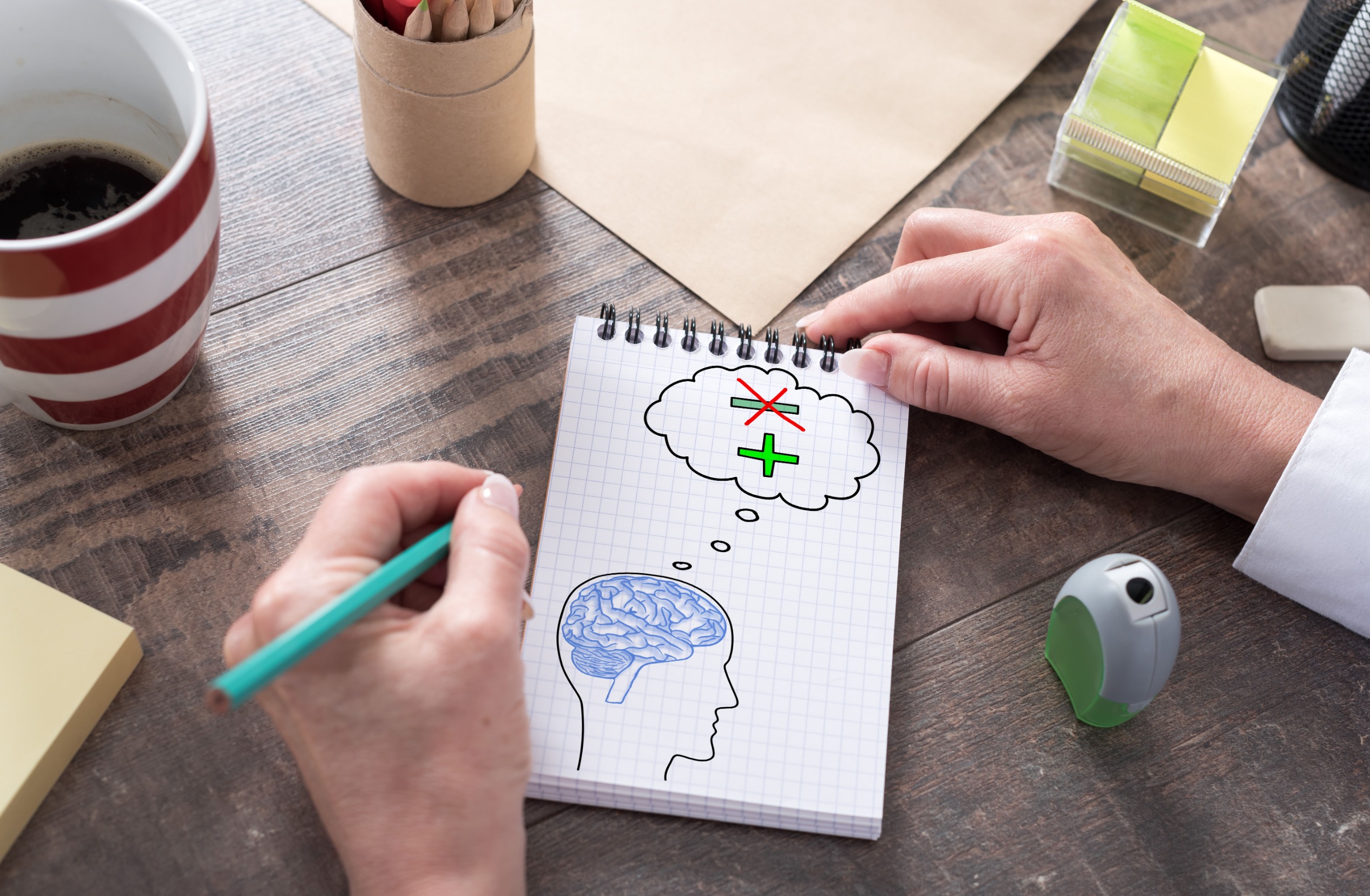 manos de hombre dibujan en blog cabeza con cerebro